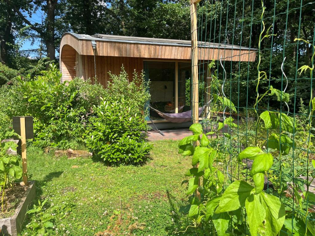 a garden with a small house with a fence at De Roek Vakantiebungalows in Otterlo