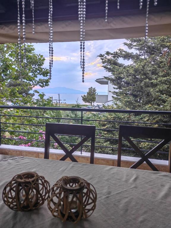 a table with two chairs in front of a window at Vicente House in Skala Rachoniou