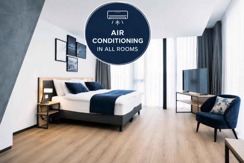 ein Schlafzimmer mit Bett, Fernseher und Stuhl in der Unterkunft YParc Hôtel, FORUM in Yverdon-les-Bains