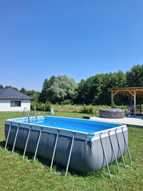 a swimming pool in a field with an inflatable at Cottage Bytheriver in Arpaşu de Sus