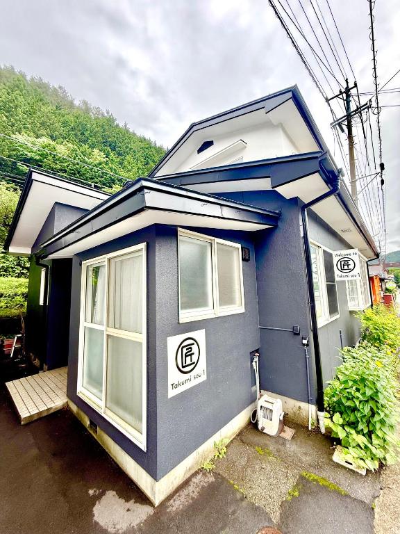 a blue tiny house is parked in a lot at Takumisou1 in Kiso