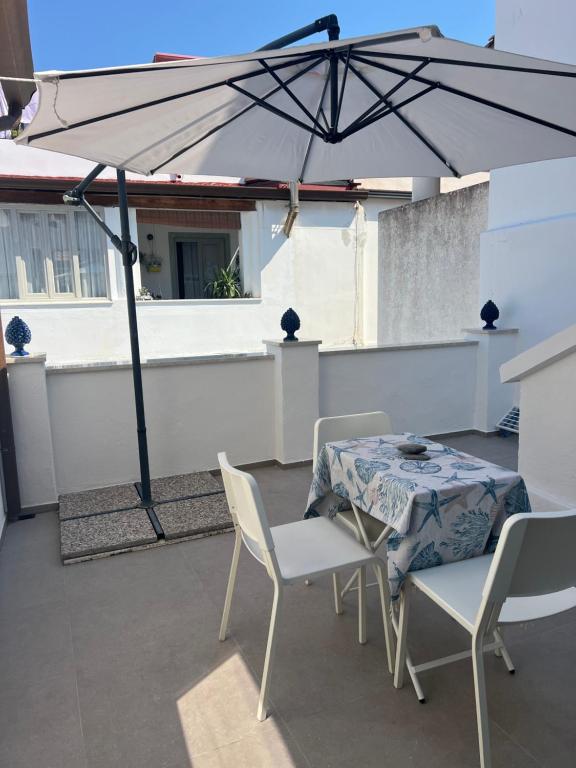 a patio with a table and chairs and an umbrella at Camilla Lipari House - Canneto in Lipari