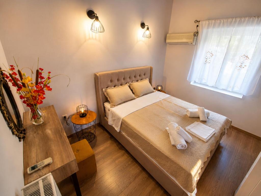 a bedroom with a bed with two towels on it at Granny's Home in Roussopoúlion