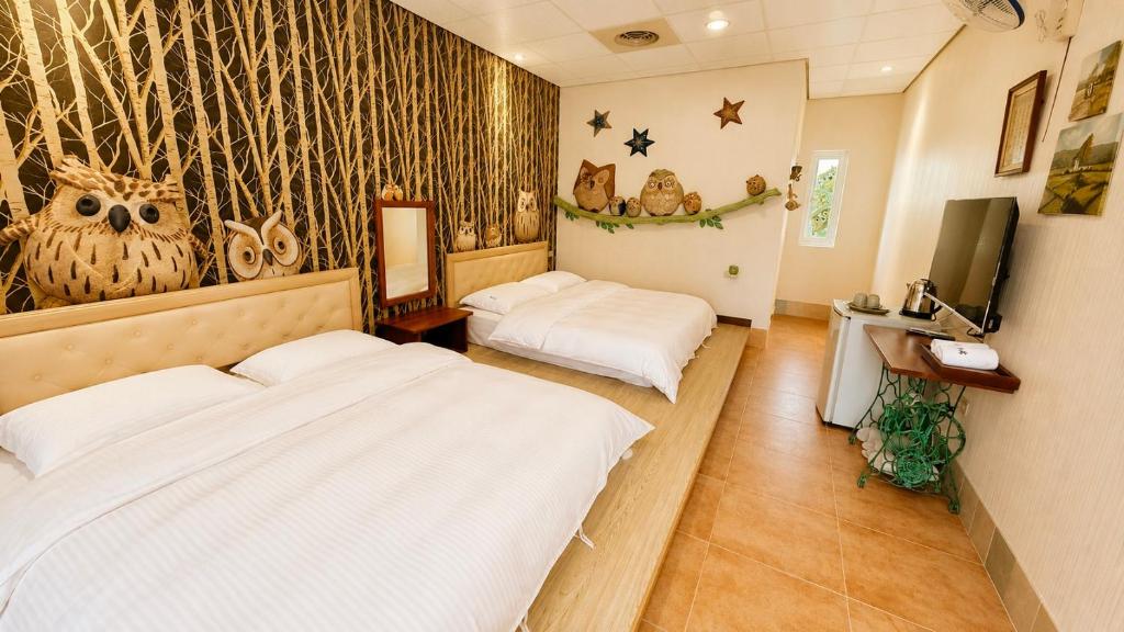a bedroom with two beds and a tv in it at Family Pottery in Hengchun South Gate