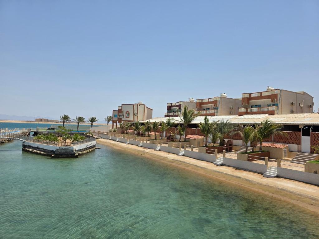 a river with buildings and a boat in the water at أصداء البحر للشقق المخدومة in Yanbu