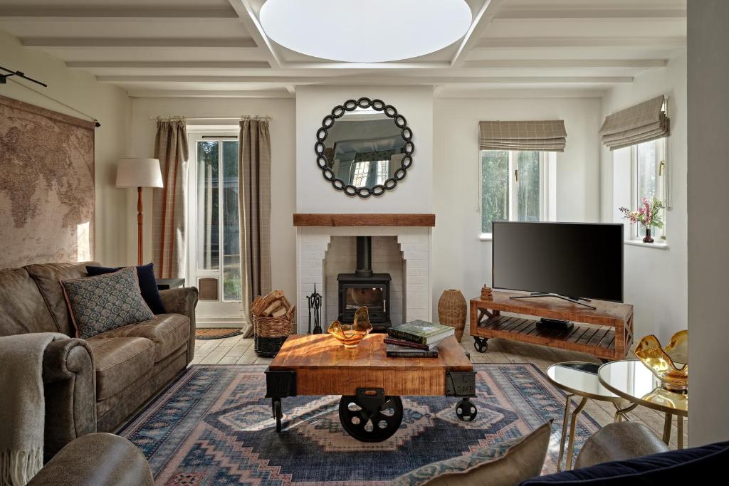a living room with a couch and a fireplace at South Lodge at Pudleston Court in Hatfield