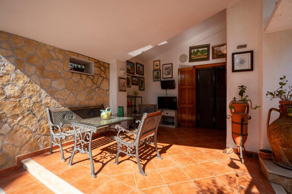 a living room with a table and chairs and a stone wall at B&B A Casa Di Gina in Polignano a Mare