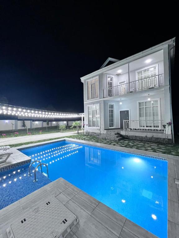 a swimming pool in front of a house at night at VIP Family Villa HOT POOL in Gabala