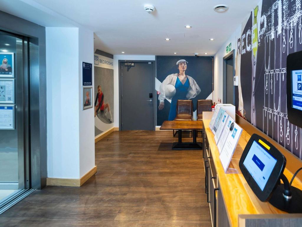 a lobby of a store with a large painting on the wall at ibis budget Swindon Town Centre in Swindon