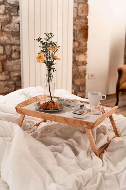 a coffee table with a vase of flowers on a bed at Ikuvium Home in Gubbio