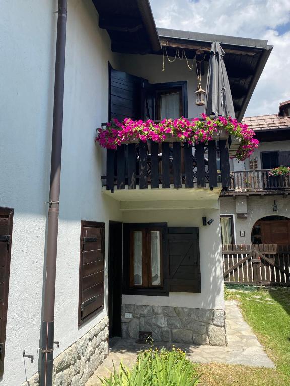a house with a balcony with flowers on it at Les Arnauds in Bardonecchia