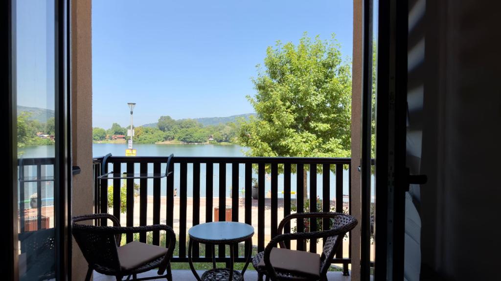 a balcony with chairs and a table and a view of a lake at Neo3 in Veliko Gradište