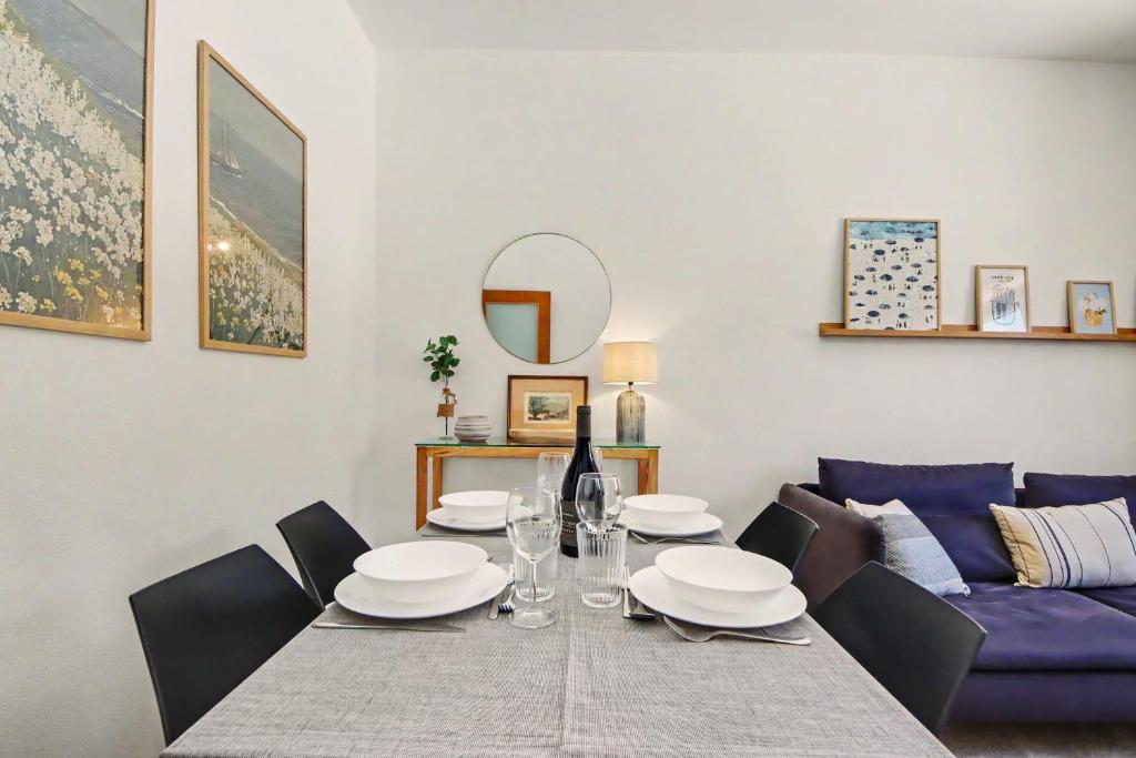 a dining room with a table and a purple couch at Driftwood - Refúgio Perto do Mar in Matosinhos