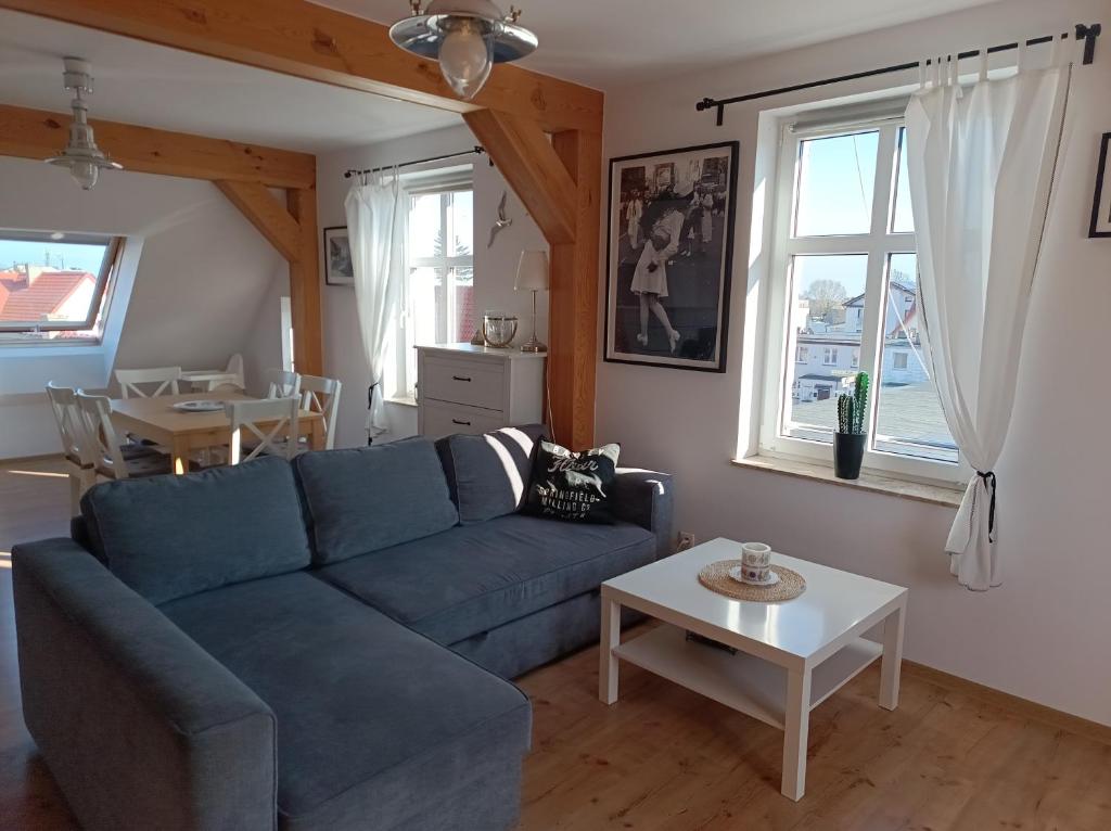 a living room with a blue couch and a table at Baltic Sea in Jastarnia