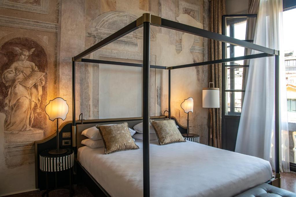 a bedroom with a black canopy bed with two pillows at Palazzo De Polo in Venice