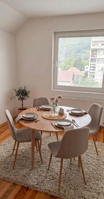 a dining room with a table and chairs and a window at Apartmani Lazaro in Višegrad
