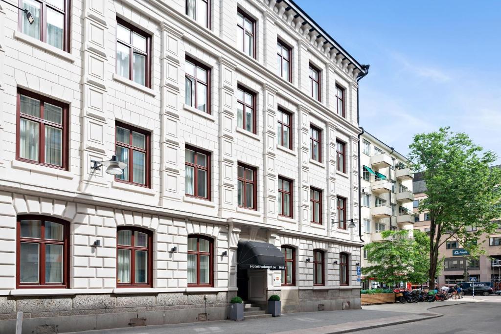 ein großes weißes Gebäude mit roten Fenstern an einer Straße in der Unterkunft Hotel Hötorget, BW Signature Collection in Stockholm