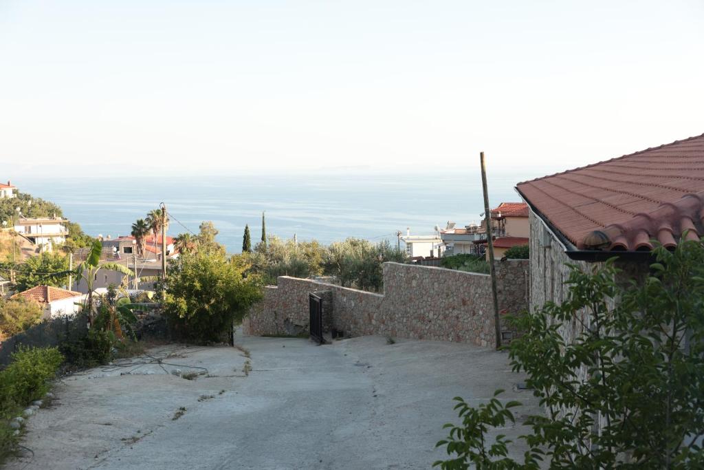 a road leading to a house with the ocean in the background at Agora Apartments in Dhërmi