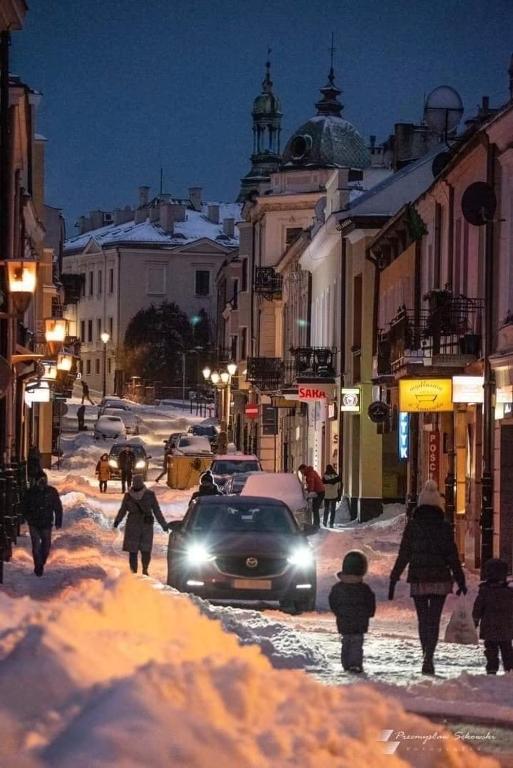 a city street covered in snow at night at Host-X Pokoje Ciche Centrum Mała Sienkiewicza -fv in Kielce