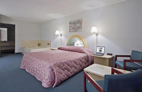 BishopvilleにあるAmericas Best Value Inn - Bishopvilleのベッドルーム1室(ピンクのベッドカバー付きの大型ベッド1台付)