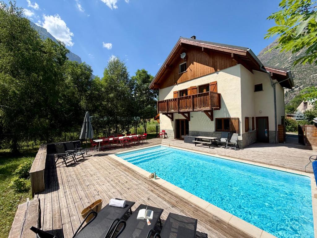 a villa with a swimming pool and a house at Chalet Les Ecrins in Vénosc