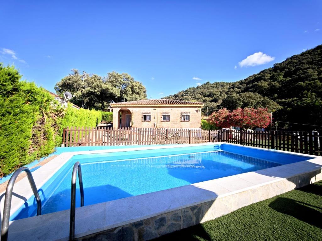 a swimming pool in front of a house at El Andén del Hueznar in Constantina
