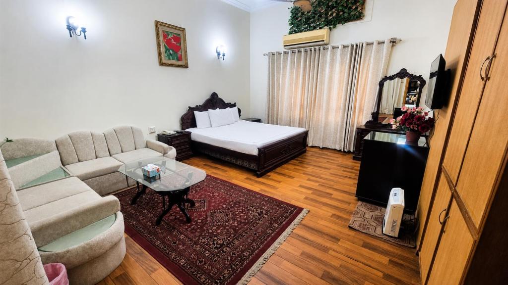 a living room with a couch and a bed at The City Lodge in Islamabad