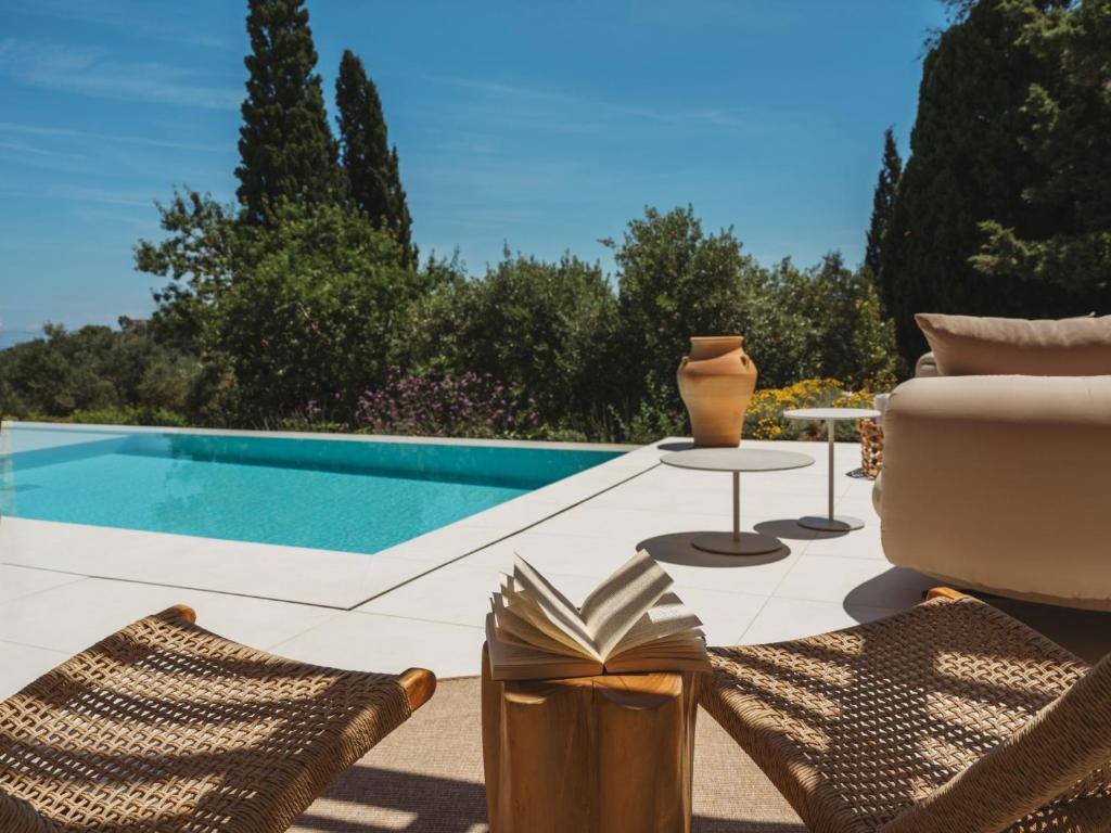 a patio with chairs and a swimming pool at Doci Kelios - Serenity Suites with Private Heated Pools, by ZanteWize in Agios Nikolaos