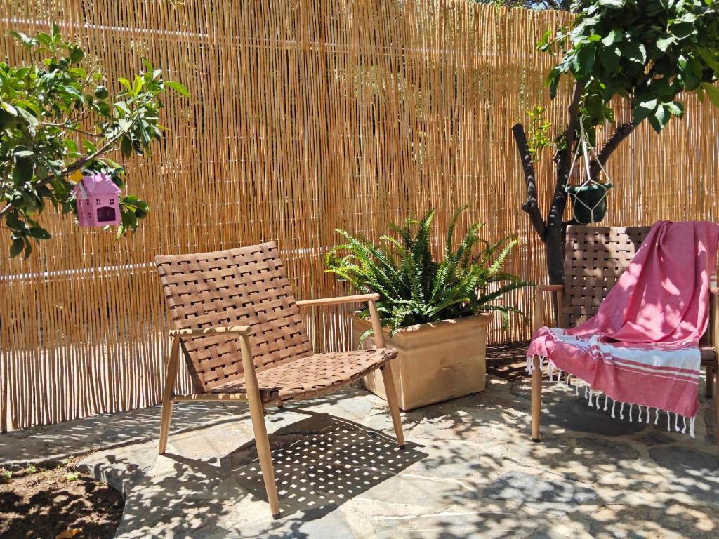 a wooden chair sitting in front of a fence at Christina's Cottage in Agios Nikolaos