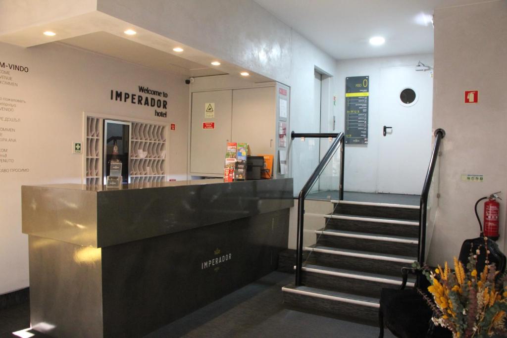 a lobby with a staircase leading to a store at Imperador Hotel in Lisbon