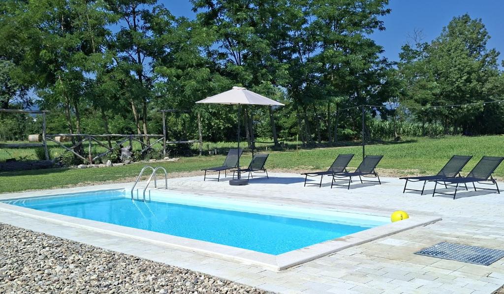 a swimming pool with chairs and an umbrella at Ranč Terzić Seosko turističko domaćinstvo in Čačak