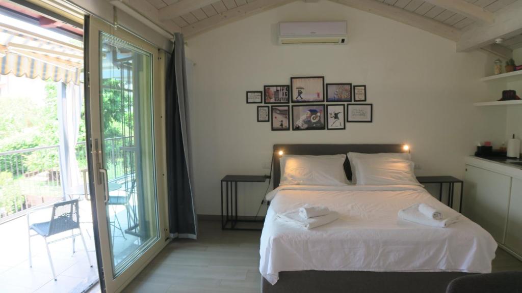 a bedroom with a white bed and a large window at OnSuite With Wiew Near COMO in Erba