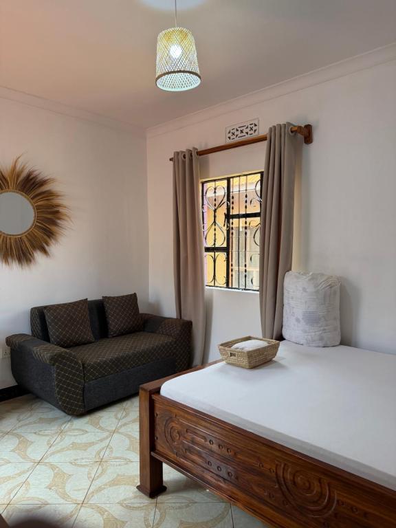 a living room with a bed and a couch at Amora Homestay and Safaris in Karatu