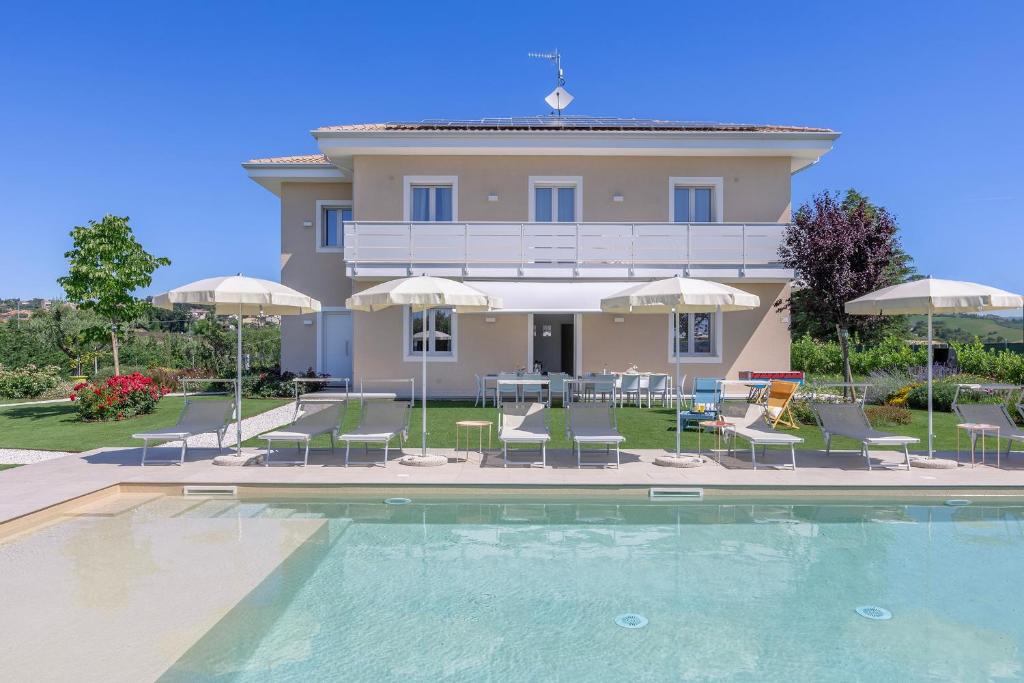 a villa with a swimming pool in front of a house at Villa Lina in Morrovalle