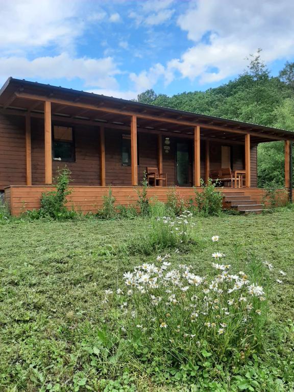 a log cabin with a grass field in front of it at Sauna v lese in Uhrovec