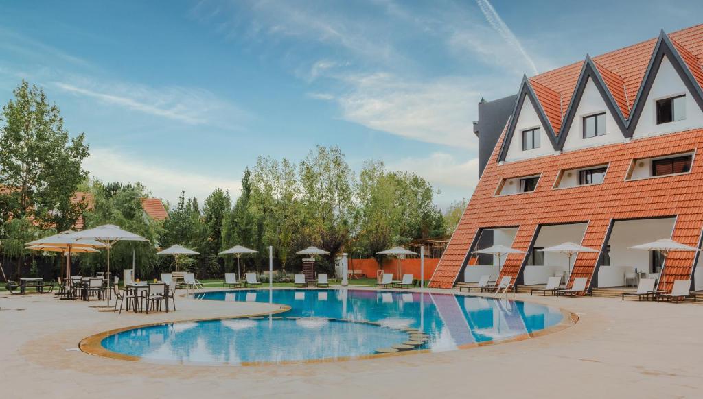 a hotel with a swimming pool in front of a building at ZEPHYR Ifrane in Ifrane