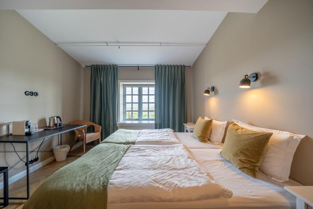 a bedroom with a large bed and a desk at Hotel Stafholt in Varmaland