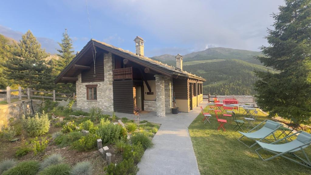 a log cabin with tables and chairs in front of it at Ca' De Sass in Pila