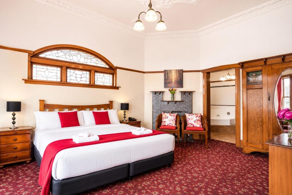 a bedroom with a large bed and a fireplace at Halswell Lodge in Wellington