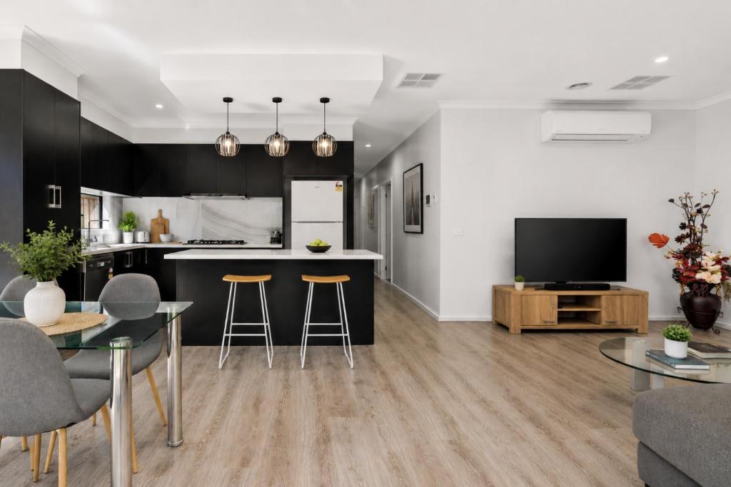 a kitchen and living room with a table and chairs at Sara by Ready Set Stay in Caroline Springs