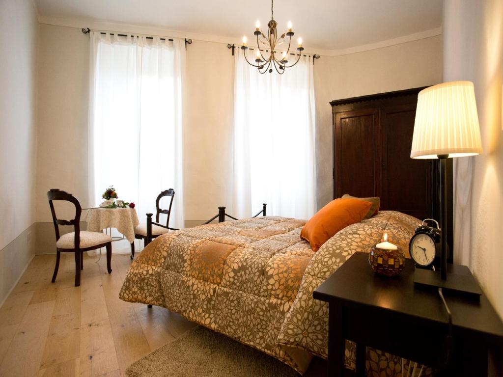 a bedroom with a bed and a table and a chair at La finestra sul Teatro in Cortona