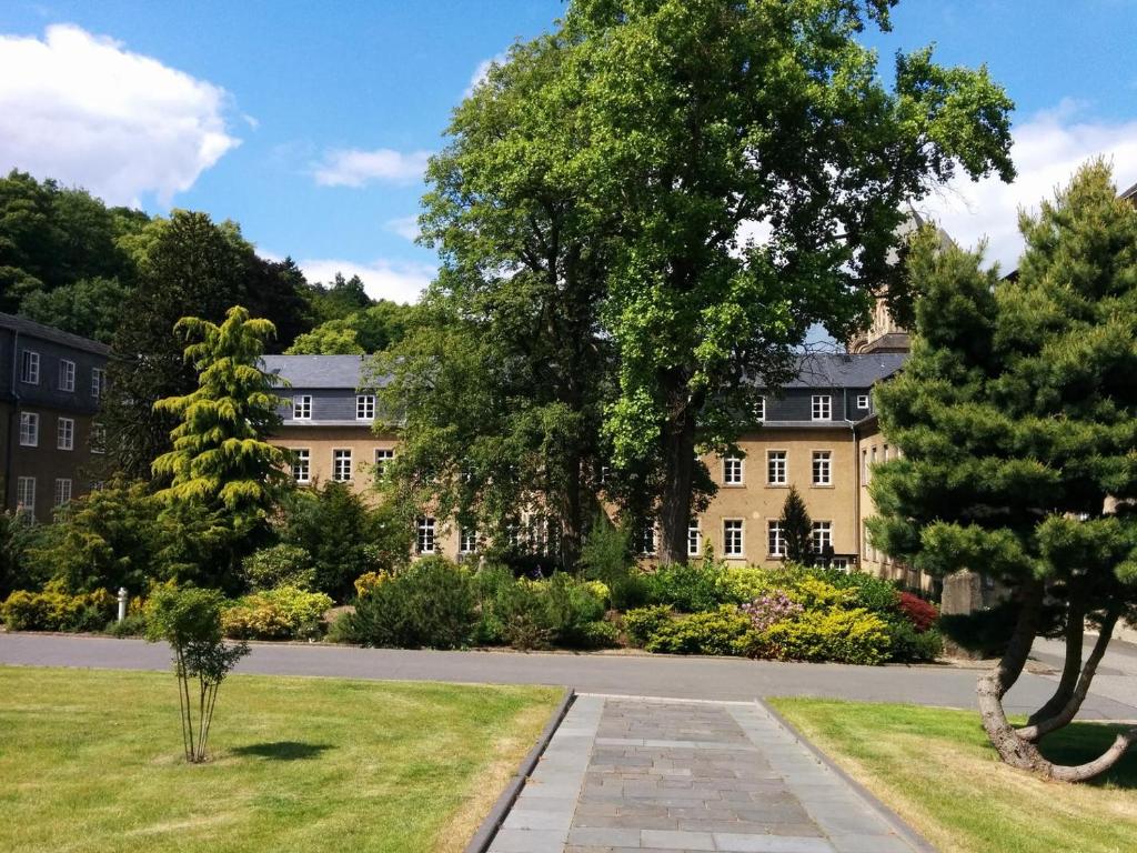 a large building with trees in front of it at Gastflügel der Abtei Maria Laach in Glees