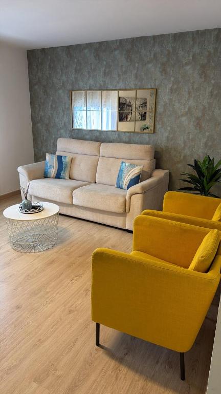 a living room with a couch and two yellow chairs at CORNELIAS HOME 1A between LAS VISTAS & LOS CRISTIANOS BEACH in Los Cristianos