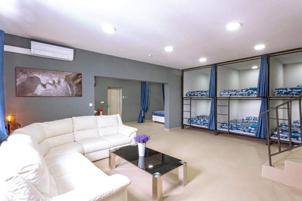 a living room with a white couch and bunk beds at Hostel IRON CUBE in Stružná