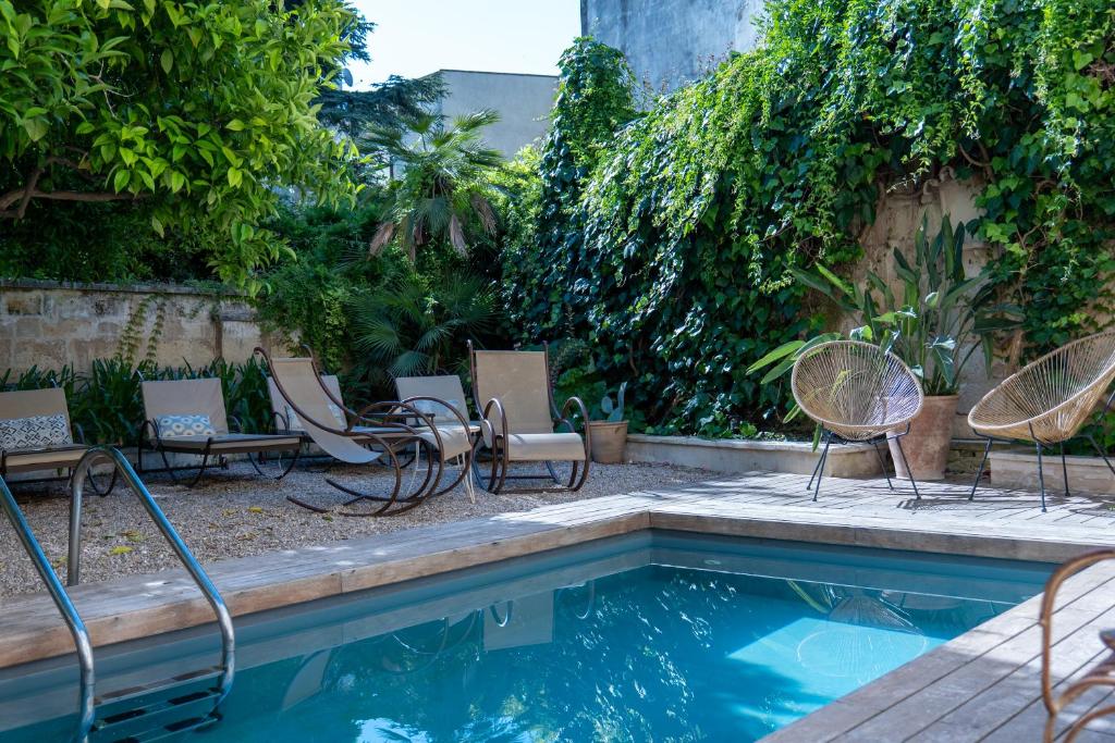 a group of chairs sitting around a swimming pool at Palazzo Maresgallo Suites & SPA in Lecce