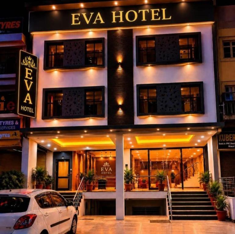 a white car parked in front of a hotel at Hotel EVA in Chandīgarh
