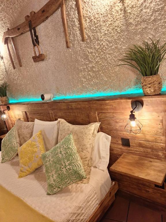 a bed with pillows on it in a room at Cueva del abuelo in El Molar
