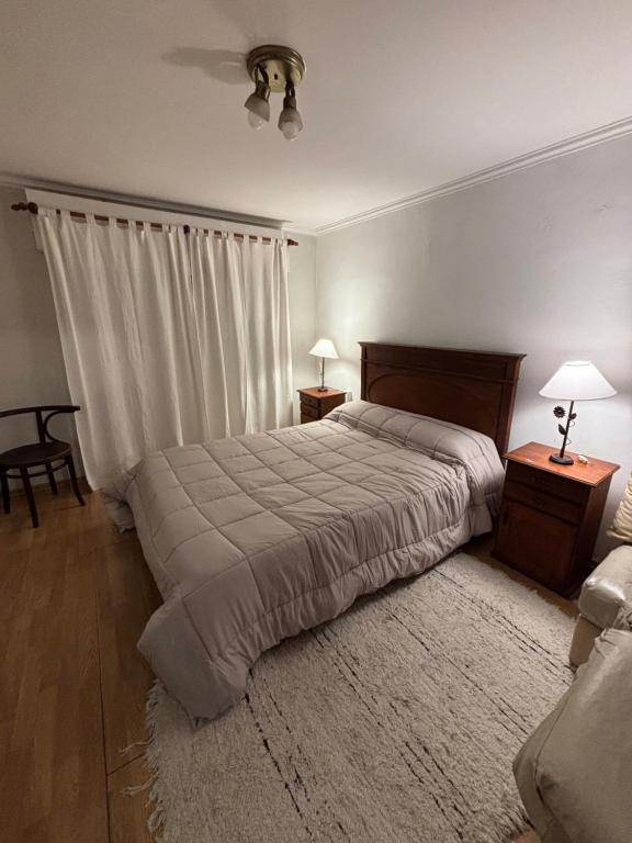 a bedroom with a bed and two night stands and two lamps at Casa Rivadavia in Rafaela