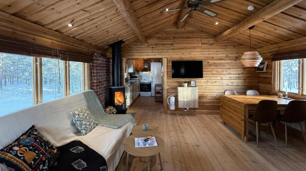 a living room with a couch and a fireplace in a log cabin at Charmig timmerstuga i Vemdalen in Vemhån