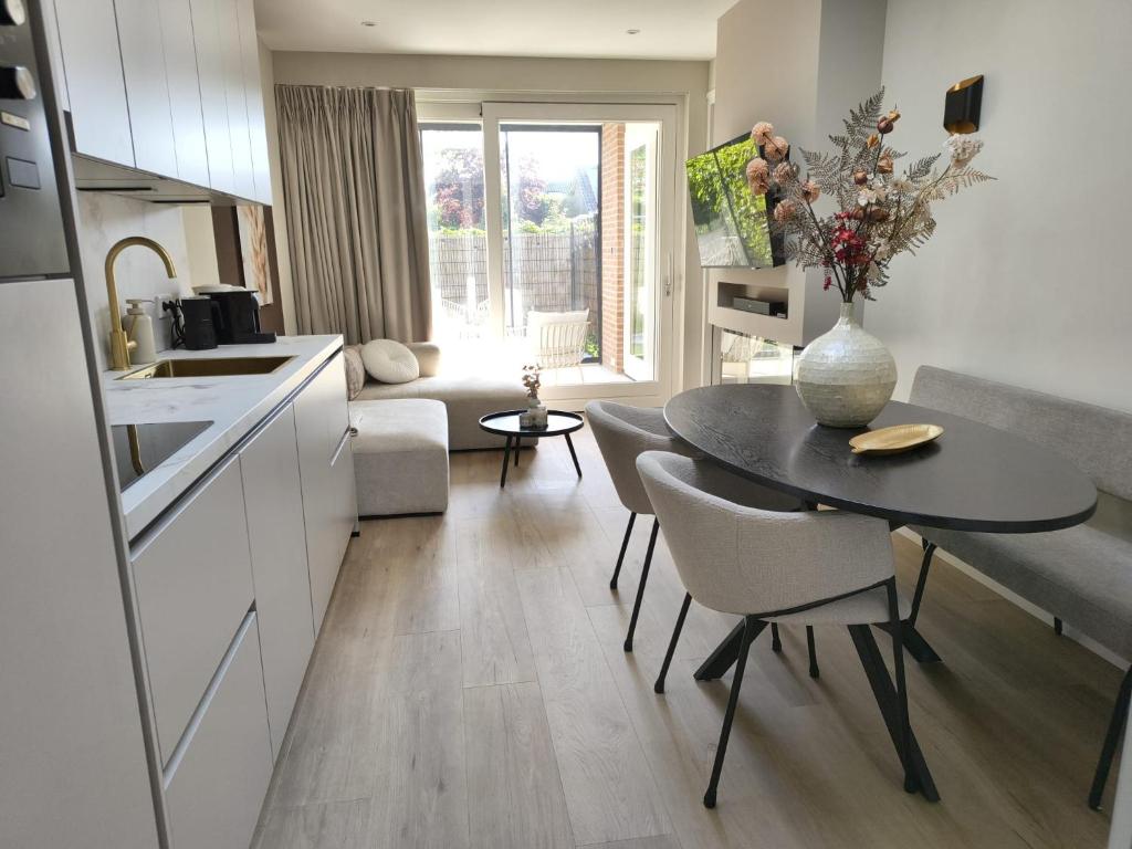 a kitchen and living room with a table and chairs at Huize Zondag in Beneden-Leeuwen